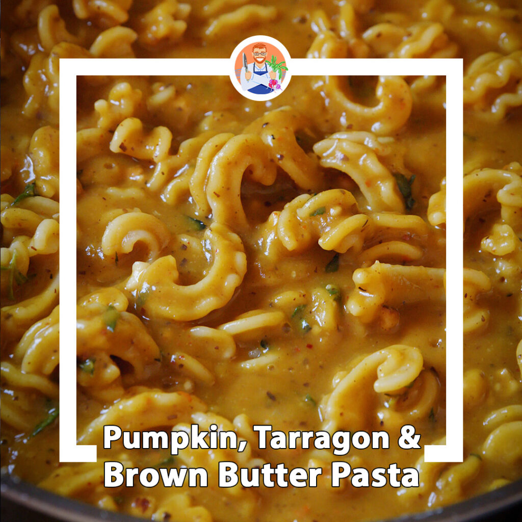 a pan full of pasta in a rich looking pumpkin sauce with herbs and spices