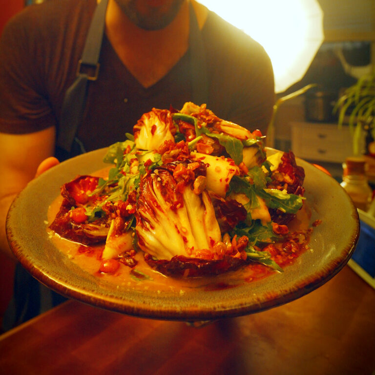 a plate of chili crisp tricolore salad in dim lighting