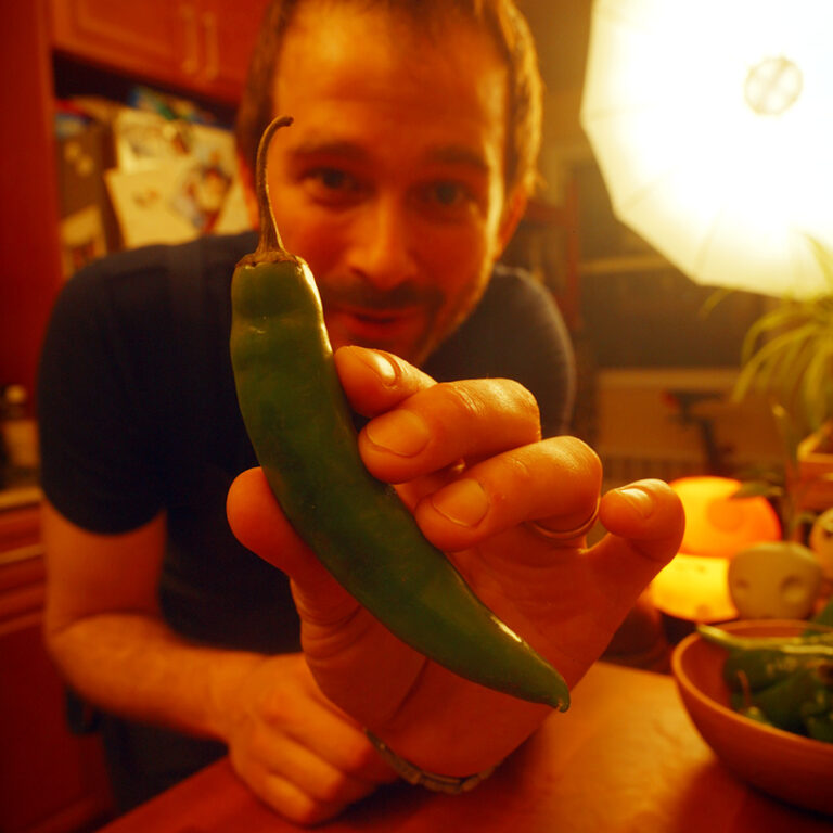 a wooden bowl full of green Korean peppers