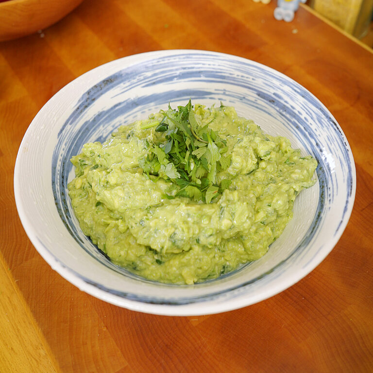 a big bowl of homemade guacamole with cilantro