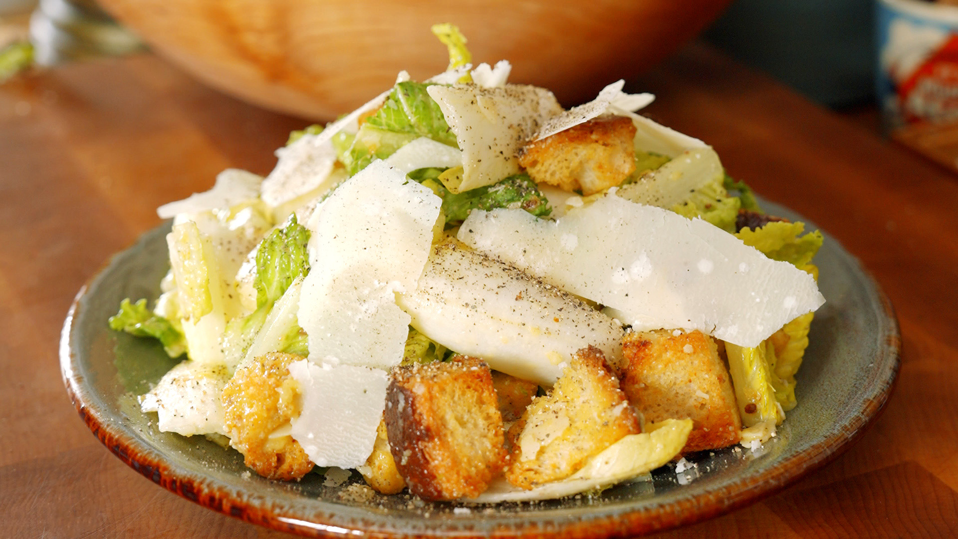 a plate full of caesar salad with big shavings of parmesan cheese