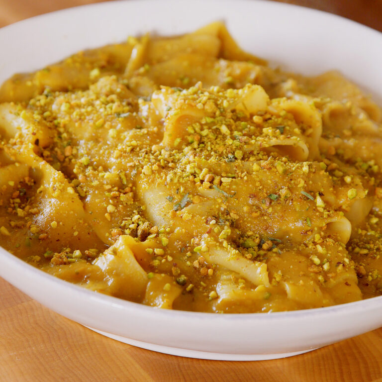 a bowl of pasta with roasted pumpkin and pistachio sauce