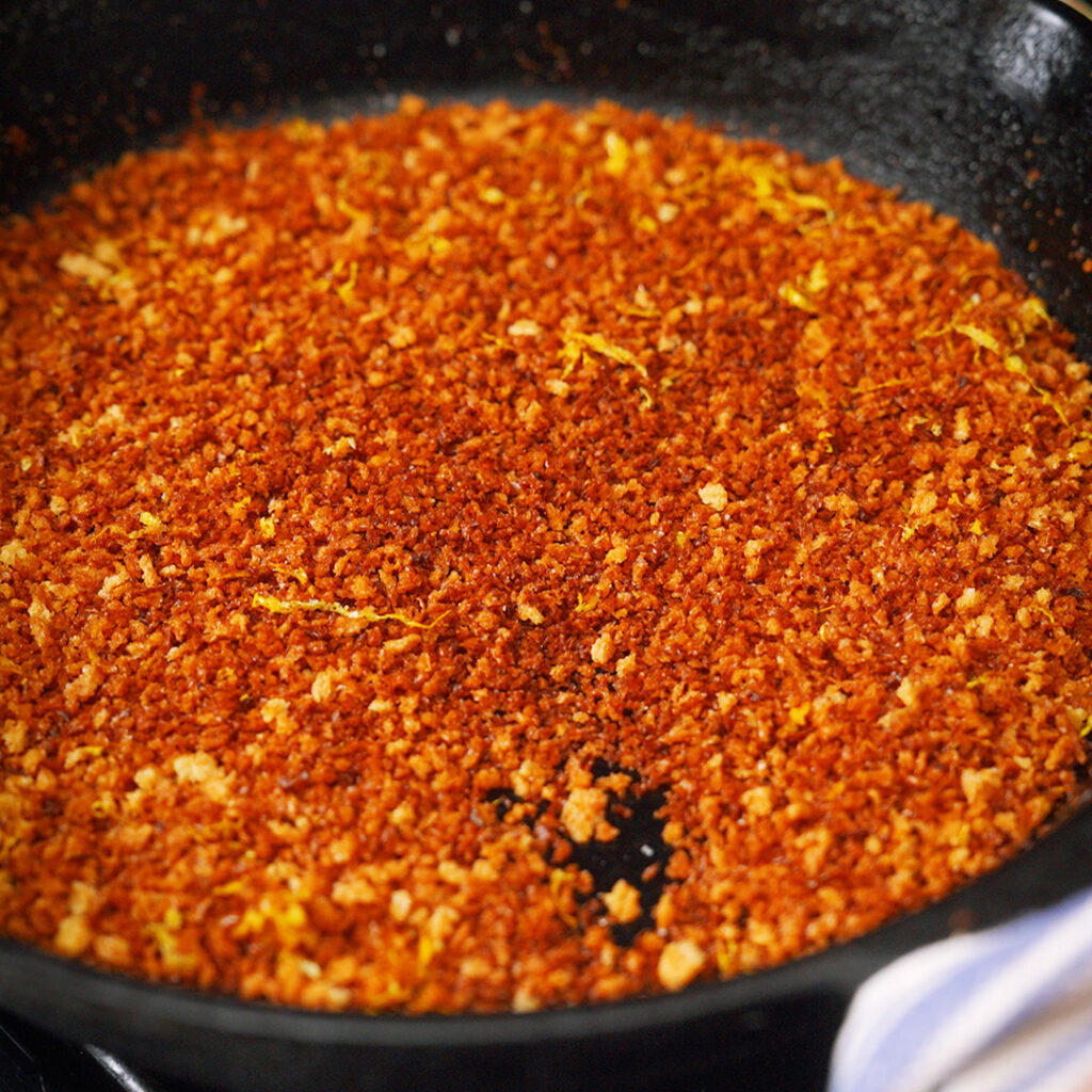lemon toasted breadcrumbs being cooked in a cast iron skillet