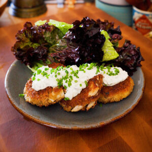 vegetarian crab cakes with homemade tartar sauce and mixed green salad on a plate
